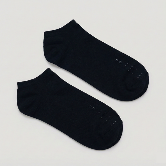Flat lay of a pair of black ankle socks. The raised black-on-black tactile markers are positioned clearly on the toe area of each sock.