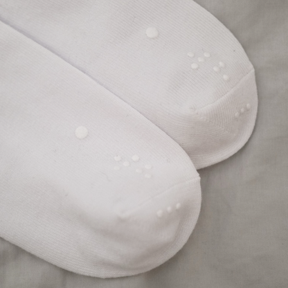 Detailed view of the toe sections of two white socks, showcasing the consistent pattern of the raised identification dots.